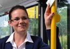 Frau in Hemd und Jacket fährt Bus