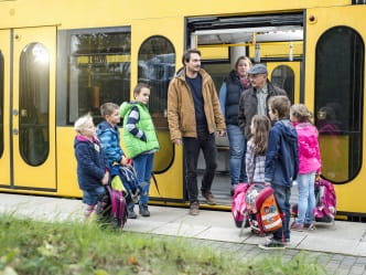 Kinder steigen in Straßenbahn ein
