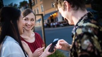 drei Personen mit einem Smartphone