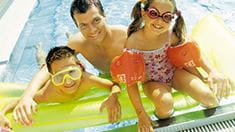 Foto junge Familie im Schwimmbecken auf Luftmatratze
