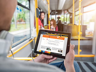Foto Fahrgast mit Tablet in öffentlichem Verkehrsmittel