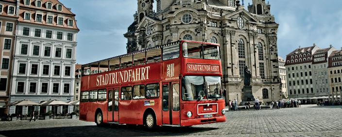 Fotografie červeného dvoupatrového autobusu před kostelem Frauenkirche