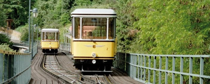 The photo shows two Standseilbahn cars meeting at the passing loop