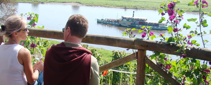 Foto Mann und Frau beim Blick von einer Bank auf die Elbe mit Elbdampfer