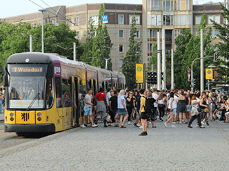 Straßenbahn an Haltestelle mit vielen Fahrgästen