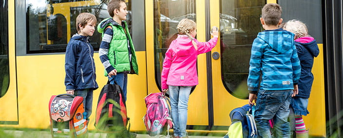 Kinder steigen in die Straßenbahn ein