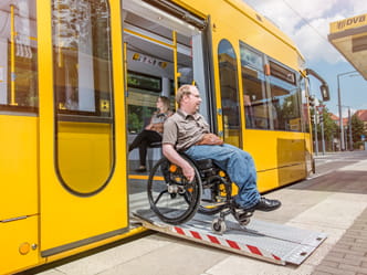 Fotografie cestujícího na invalidním vozíku při výstupu z tramvaje po rampě