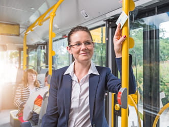 Das Foto zeigt eine Geschäftsfrau im Bus.