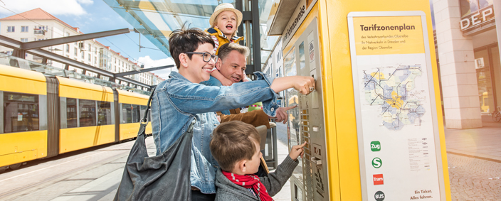 Das Foto zeigt eine Familie beim Ticketkauf vor einem Ticketautomat.