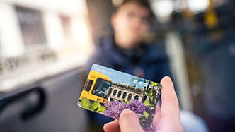 Schüler hält Fahrkarte in der Hand