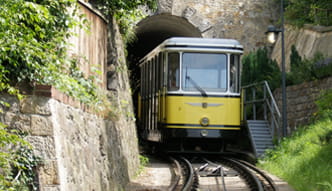 The photo shows two Standseilbahn cars meeting at the passing loop