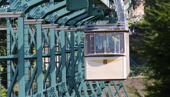 Foto Beige Schwebebahn in einer Frontalperspektive erklimmt den Elbhang
